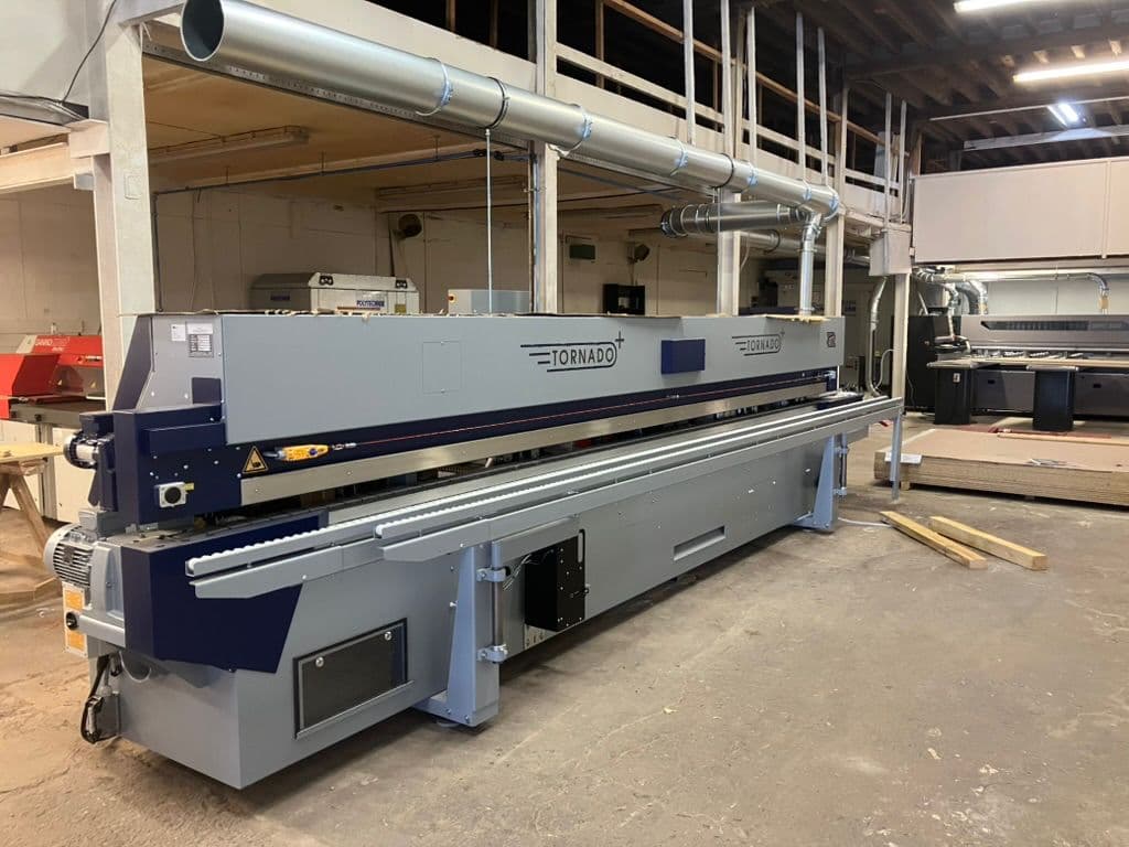 Edgebander applying tape to a panel edge